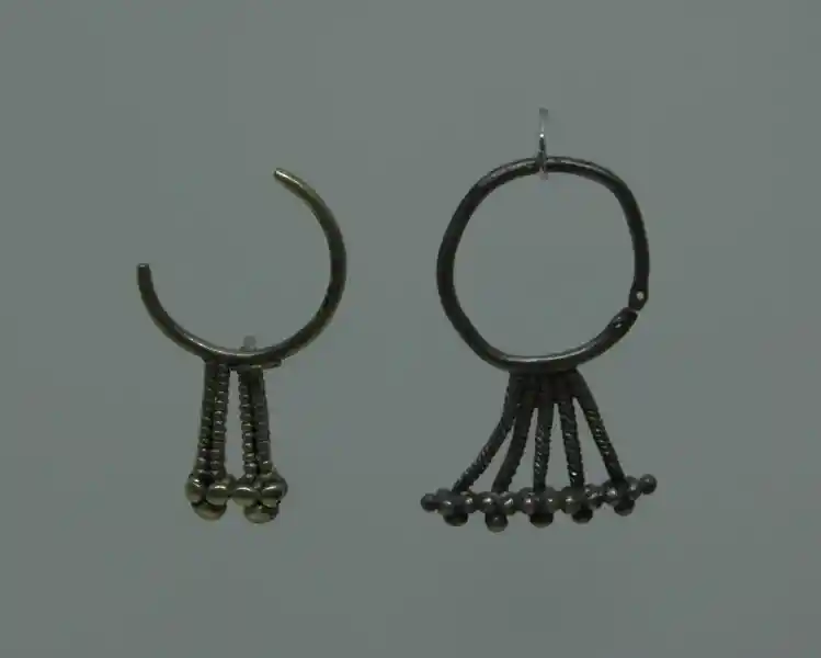 Small spheres form crosses as pendants on an earring